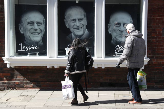 Members of the public walk past a gallery in Windsor High Street, containing pictures of the duke (Andrew Matthews/PA)