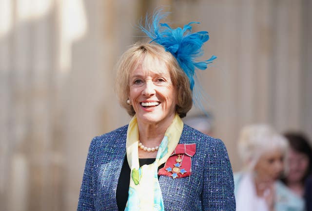 Esther Rantzen smiles while wearing a hat 