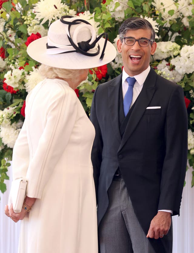 Prime Minister Rishi Sunak laughs as he chats to Queen Camilla