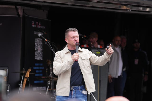 Tommy Robinson speaking on stage during a Unite the Kingdom march