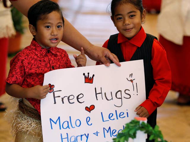 Children greeted the royal couple with the offer of a free hug - which Meghan spotted and smiled at 