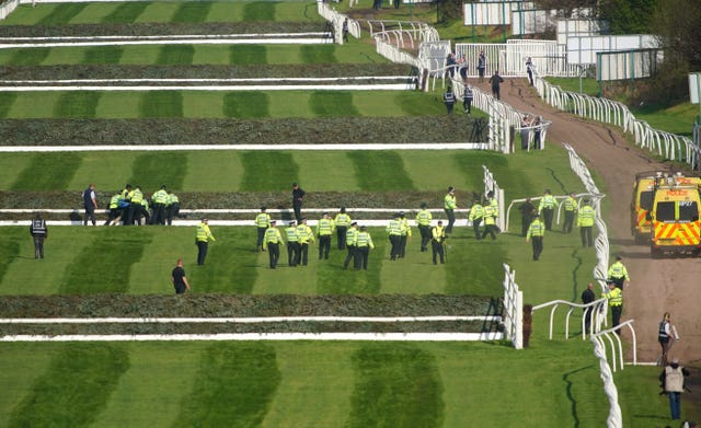 Police officers respond to Animal Rising activists attempting to invade the course at Aintree