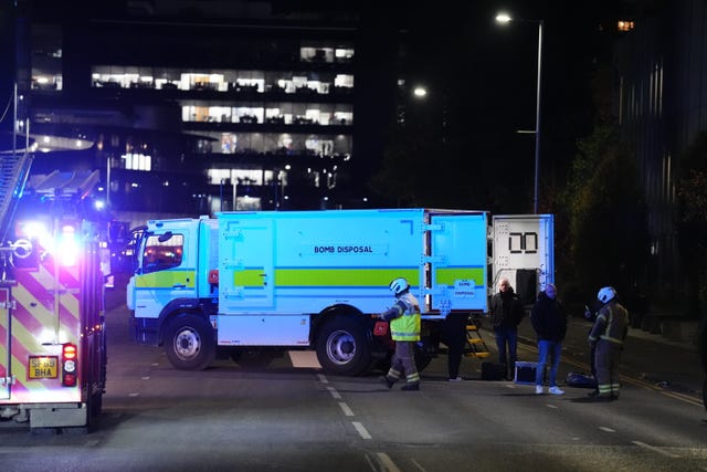 Bomb disposal truck and fire engine parked on road