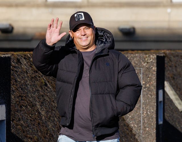 James English smiling and waving while walking outside
