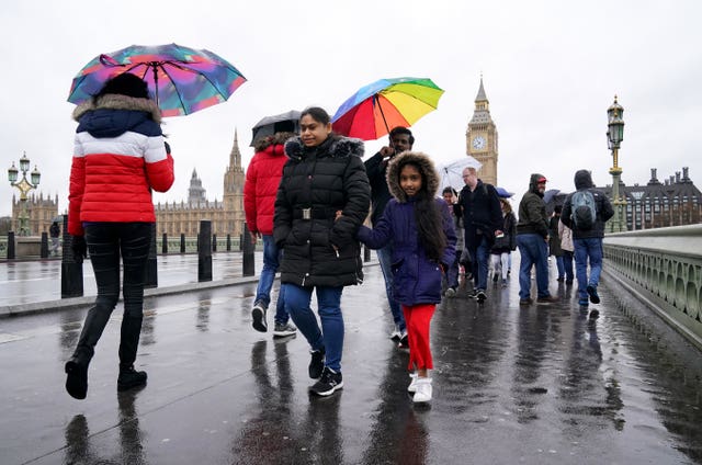 People brave the rainy conditions on Westminster Bridge, London