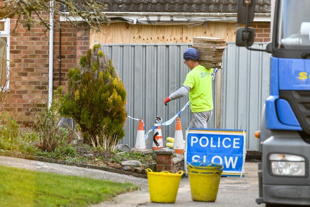 Contractors carry wooden scaffolding planks outside the home of former Russian spy Sergei Skripal in Salisbury