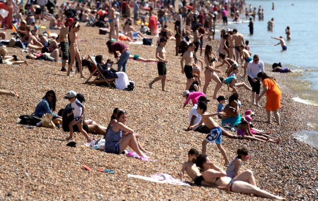 People enjoying the hot weather on Brighton beach (Steve Parsons/PA)