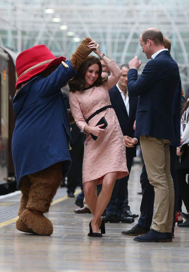 The Duke of Cambridge watched as his wife the Duchess of Cambridge danced with Paddington bear on platform 1 at Paddington Station, London, as they attend the Charities Forum event. (Jonathan Brady/PA)