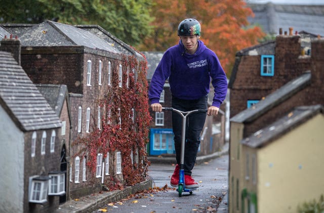 Jack Hopton-Butler, from Wimborne’s StreetLight Project, scooters through the streets of Wimborne Model Town and Gardens in Dorset