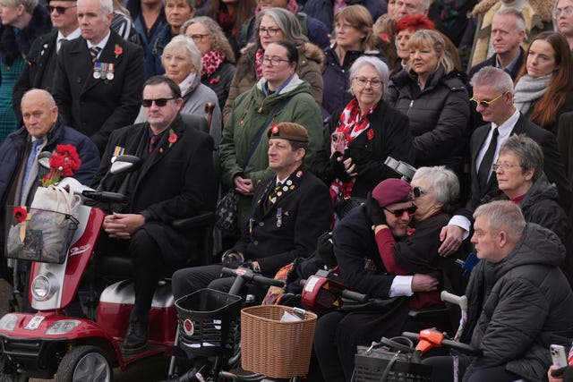 Crowd of people, including veterans wearing medals