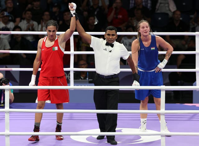 Imane Khelif with her hand in the air by the referee after winning her match