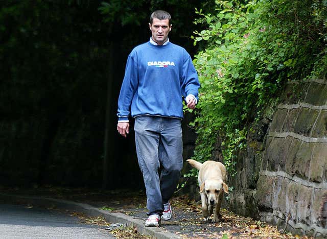 Roy Keane walks his dog outside his home in Hale Barnes after being sent home from the World Cup
