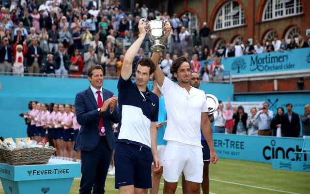 Andy Murray (left) and Feliciano Lopez hold the Queen's doubles trophy aloft