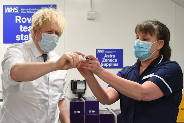 Prime Minister Boris Johnson is shown a vial of the Oxford/AstraZeneca coronavirus vaccine during a visit to Barnet FC’s ground at The Hive, north London, which is being used as a coronavirus vaccination centre