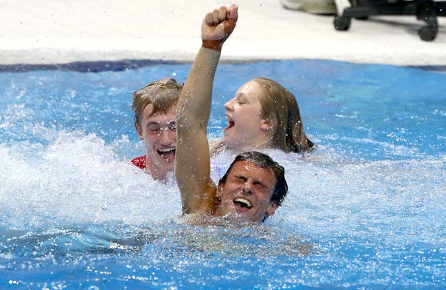 Tom Daley is thrown into the diving pool by his team-mates after winning Olympic bronze