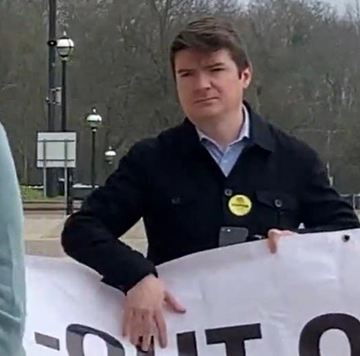 Michael McMonagle holding a banner