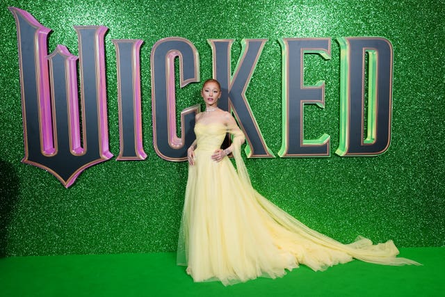 Ariana Grande in a lime green dress before the Wicked movie marquee