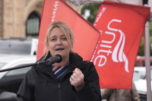 Unite general secretary Sharon Graham makes aa speech in front of red Unite flags