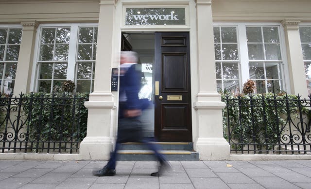 Man blurred as he walks past a WeWork office