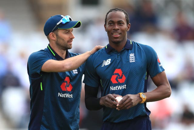 Mark Wood pats England team-mate Jofra Archer on the shoulder.