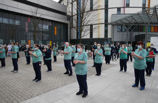 People clap after observing a minute’s silence outside the Queen Elizabeth University Hospital in Glasgow