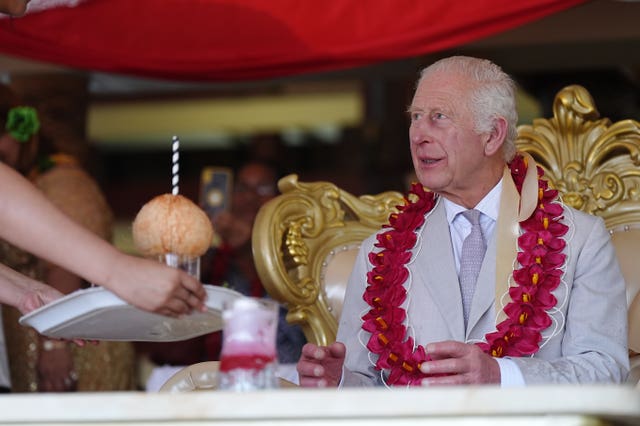 Charles is presented with a drink during a farewell ceremony at Siumu Village on the final day of the royal visit to Australia and Samoa 