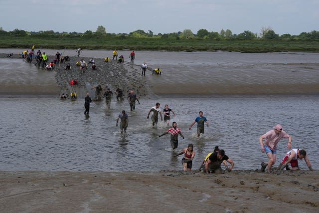 Competitors take part in the annual Maldon Mud Race, a charity event to race across the bed of the River Blackwater in Maldon, Essex