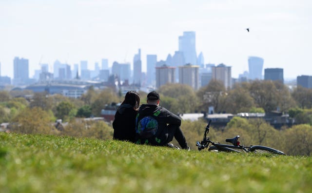 People sit on Primrose Hill, London (Kirsty O'Connor/PA)