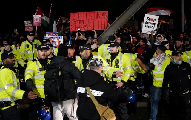 Police officers watch pro-Palestine protesters outside Villa Park during the November game 