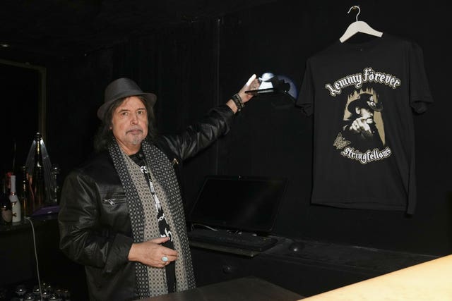 Phil Campbell poses next to the urn that contains part of the ashes of Lemmy from Motorhead, which is placed behind the bar at Stringfellows nightclub in London, to honour the wishes in his will that part of his ashes be kept in an urn behind the bar of his favourite establishment