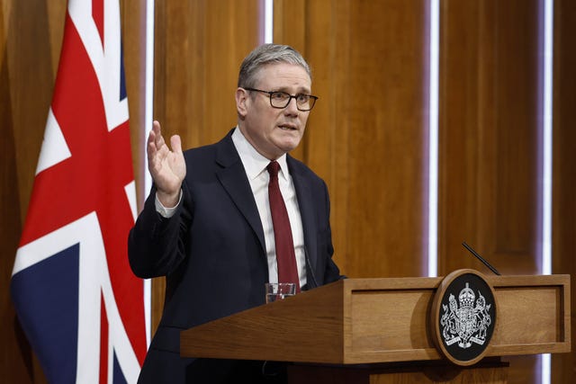 Sir Keir Starmer speaking at a podium in front of a union flag