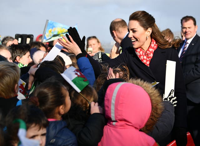 The Duchess of Cambridge high-fives children in the crowd