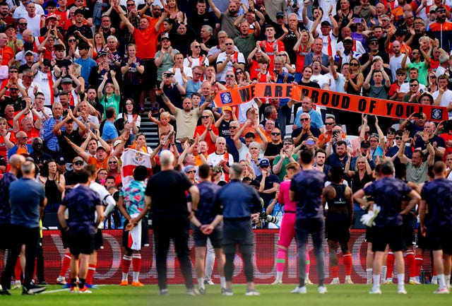 Luton fans applaud their players and hold up a banner reading 'We are proud of you' after defeat to West Ham