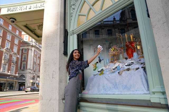 Student polishes shop window