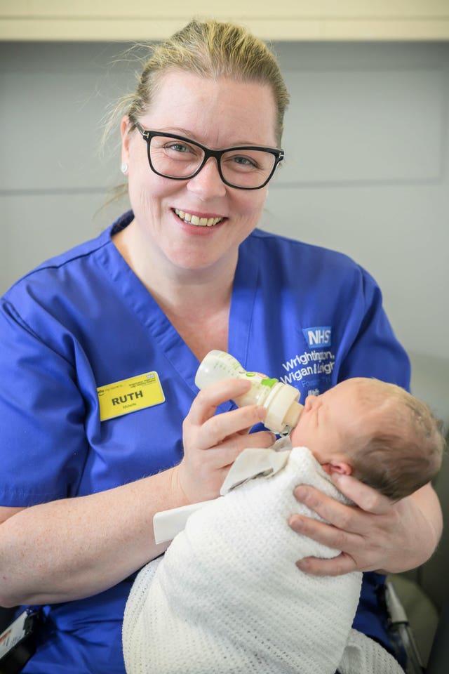 Midwife Ruth Breen feeding a bottle to a baby