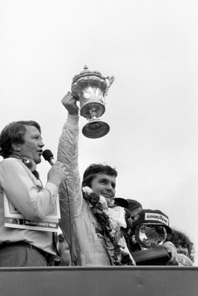 Australia’s Alan Jones lifts the winners trophy after victory in the British Grand Prix at Brands Hatch aboard his Saudia Leyland Williams