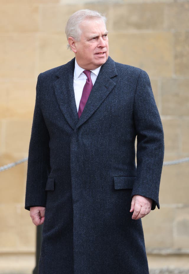 The Duke of York walks in a dark suit and overcoat