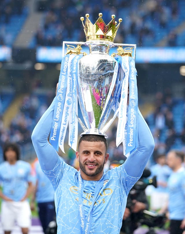 Kyle Walker smiles as he lifts the Premier League trophy