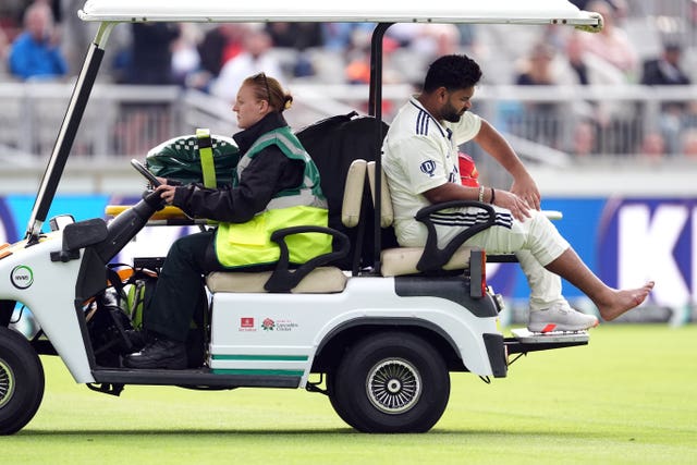 Rishabh Pant (centre right) was taken off the field in a golf buggy