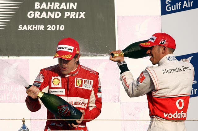 Alonso and Lewis Hamilton, right, celebrate after the Spaniard won the 2010 Bahrain Grand Prix