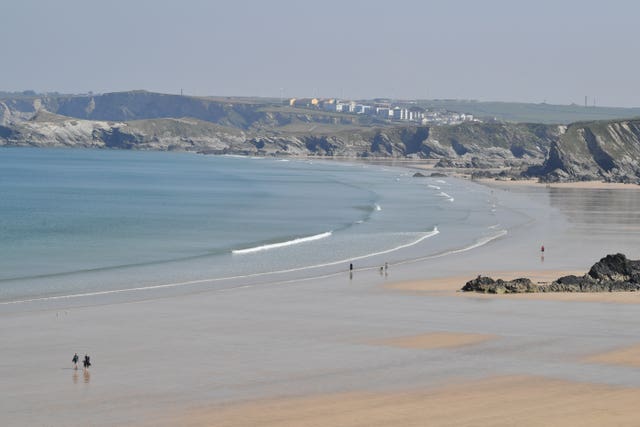 People walk on the Tolcarne beach in Newquay (Ben Birchall/PA)