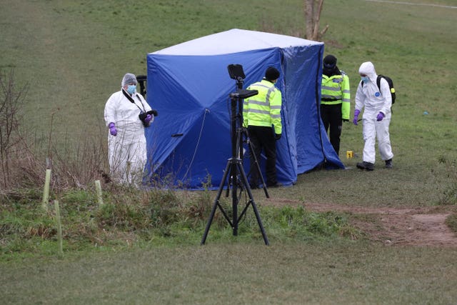 Forensic officers at the tent in Bugs Bottom field in Emmer Green, Reading, where a 13-year-old boy died after being stabbed on Sunday