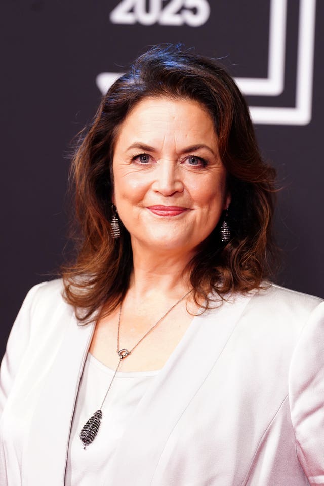 Head and shoulders photo of Ruth Jones smiling at a red carpet event, wearing a pale pink top and blazer