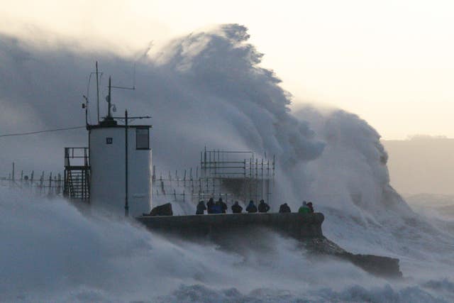 Waves crash against the sea wall and Porthcawl Lighthouse in Porthcawl, Bridgend, Wales, during Storm Eunice 