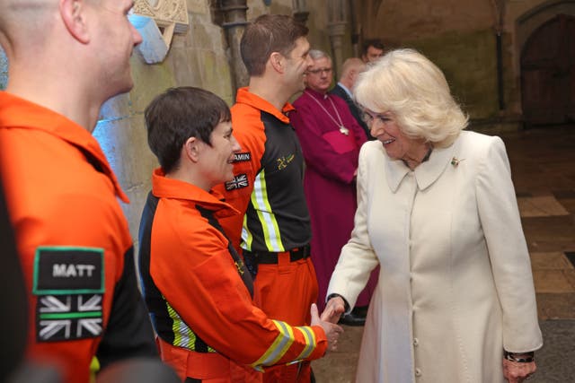 Queen Camilla is greeted by air ambulance charity reps as she attended a musical evening at Salisbury Cathedral in Wiltshire, 