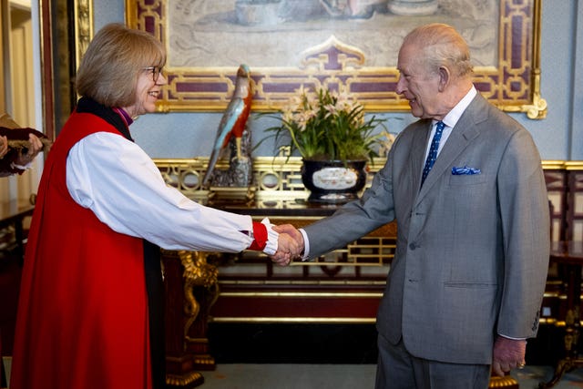 The King and Archbishop shake hands in Buckingham Palace 