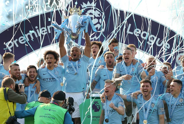 Foden celebrates with his team-mates as captain Manchester City captain Vincent Kompany lifts the Premier League trophy after victory at Brighton