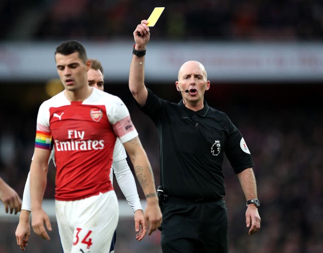 Mike Dean, right, books Arsenal’s Granit Xhaka