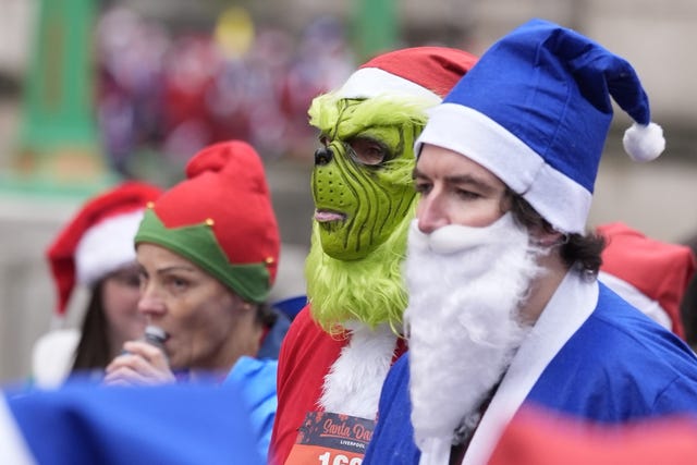 A Grinch mask beside a blue Santa 