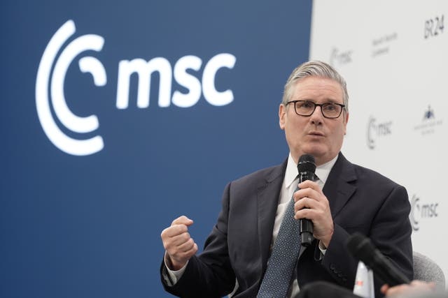Sir Keir Starmer speaking into a microphone which he is holding in his left hand